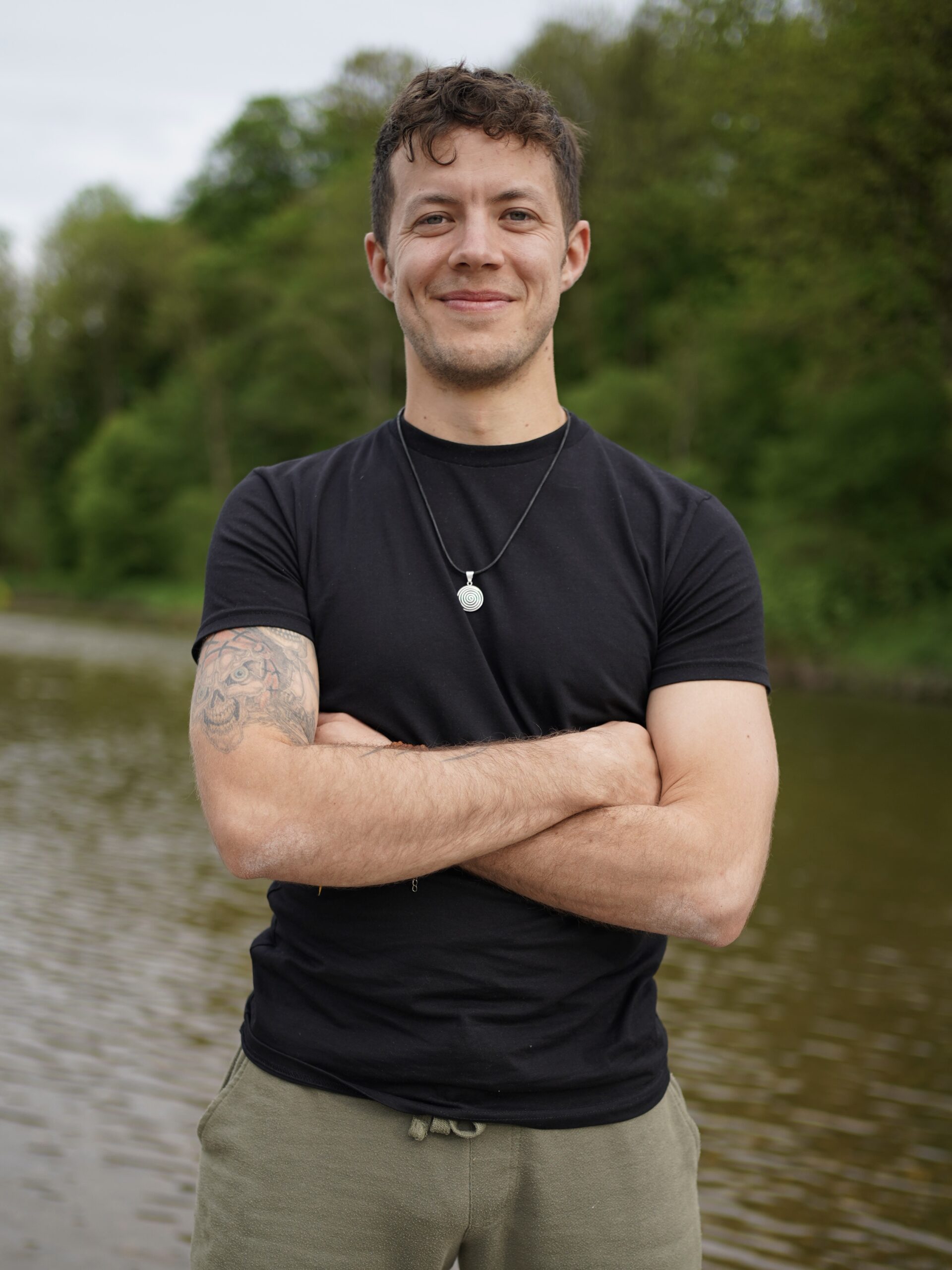 author-foto Julian vor einem Fluss mit einem Lächeln
